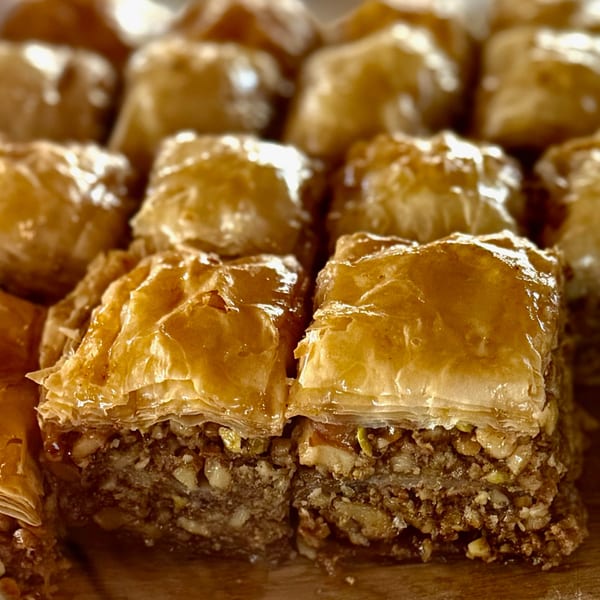 Close-up of golden-brown baklava squares with flaky pastry and a rich nut filling.